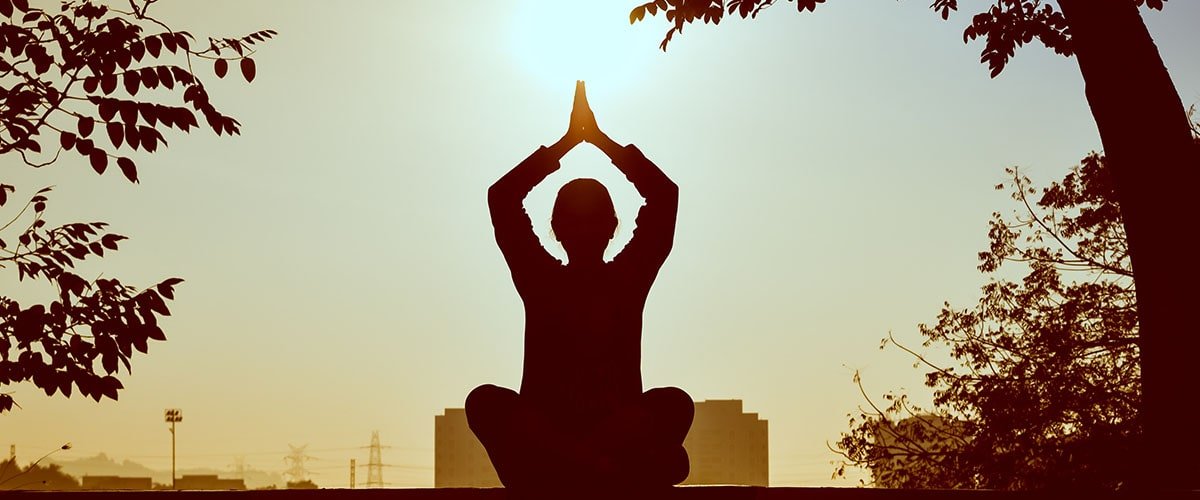 Gün batımında yoga ve pranayama meditasyonu silüeti